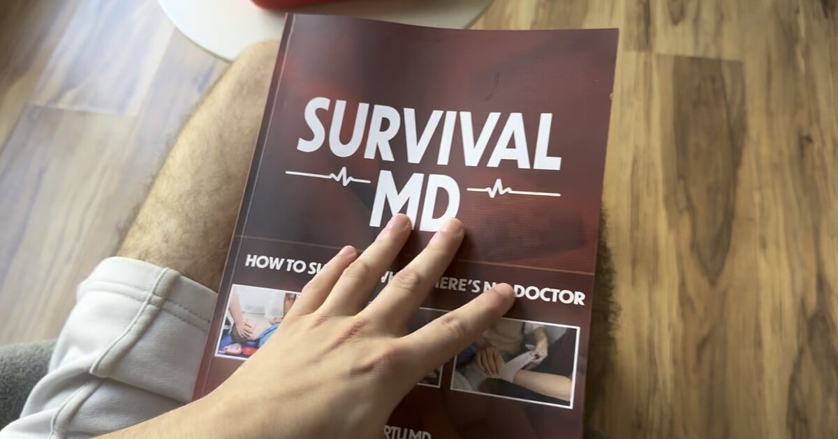 A reader with the printed Survival MD book by Dr. Radu Scurtu on their lap